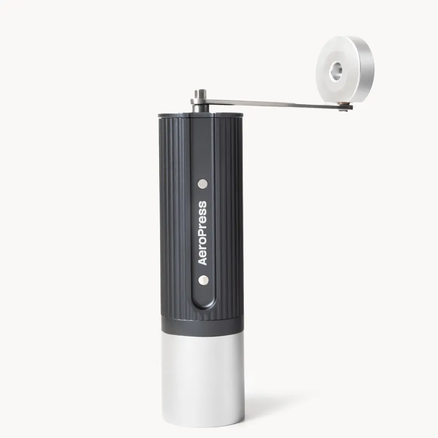 AeroPress Manual Coffee Grinder in dark gray and silver with its crank handle attached