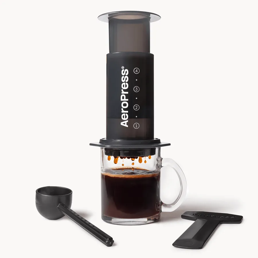 AeroPress Original coffee maker pressing coffee into a glass mug