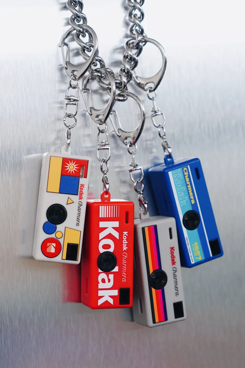 Four Kodak Charmera keychain cameras hanging from metal clips