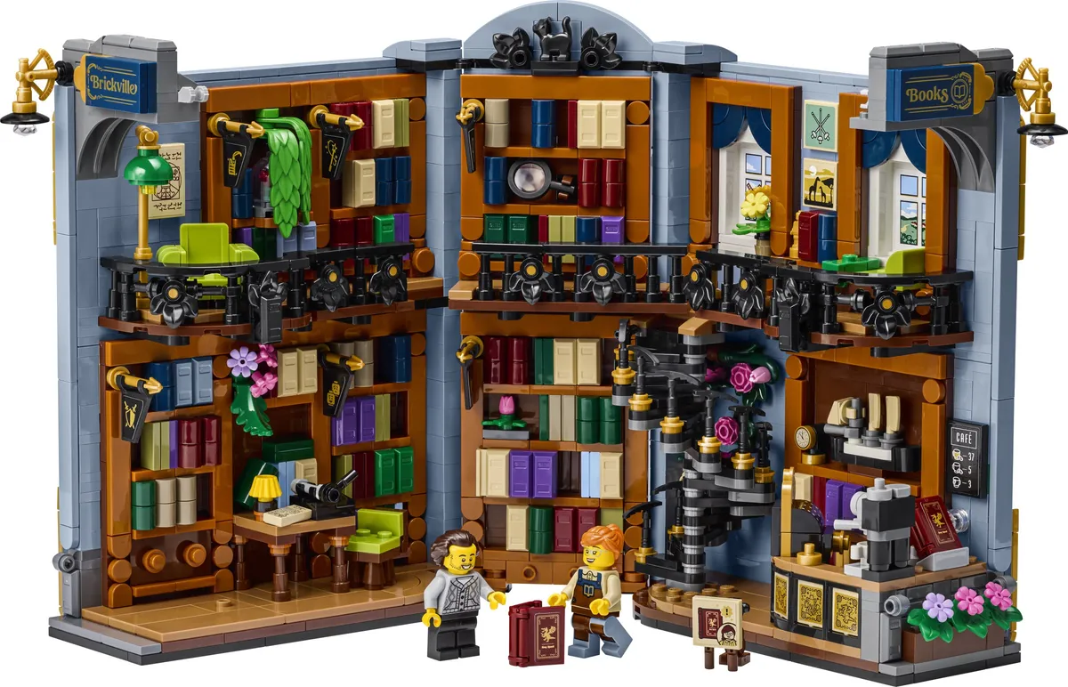 LEGO Icons Bookstore Book Nook 11379 opened up, showing two floors of bookshelves, a spiral staircase, balconies and two minifigures
