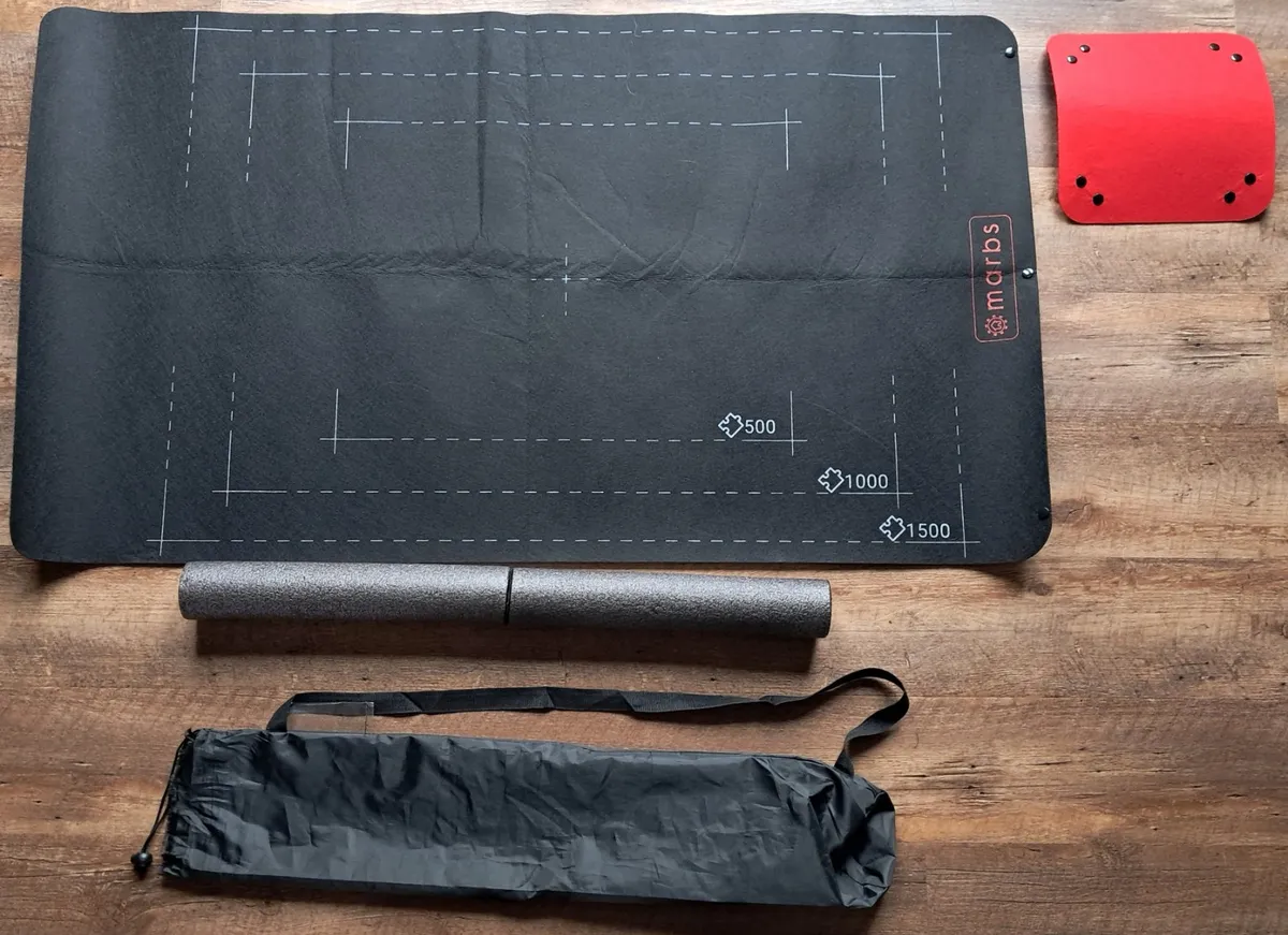 Black Marbs roll-up puzzle mat with foam tubes, sorting tray and storage bag
