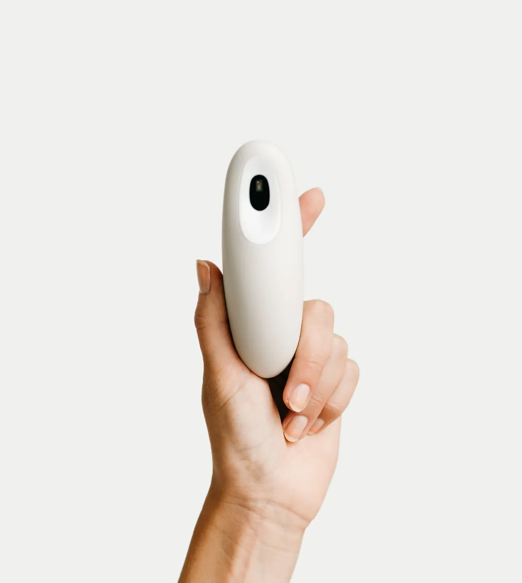 Soft white Moonbird breathing coach held in a hand