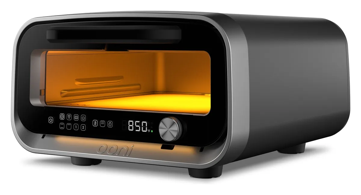 Ooni Volt 2 electric pizza oven in charcoal grey with a glowing orange interior