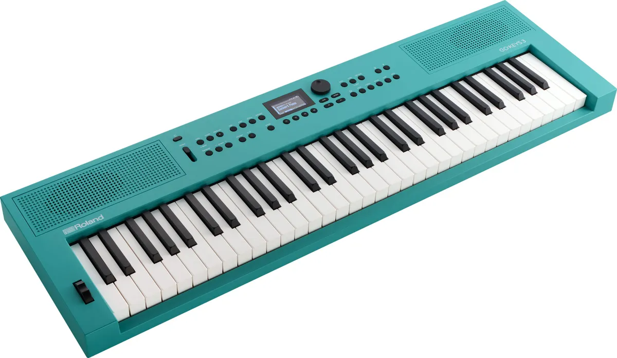 The Roland GO 3 keyboard in turquoise, angled view with speaker grilles on both sides of the control panel